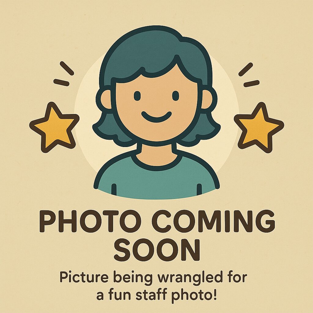 Gender-neutral cartoon placeholder image for a staff member, featuring a smiling character with teal hair and shirt, surrounded by stars and the text “Photo Coming Soon.”